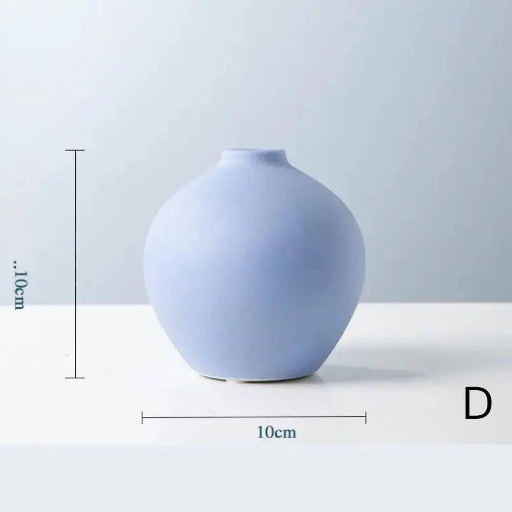 A sleek black ceramic vase with a rounded base and narrow neck, measuring 10cm in diameter and 7cm in height, on a light background.