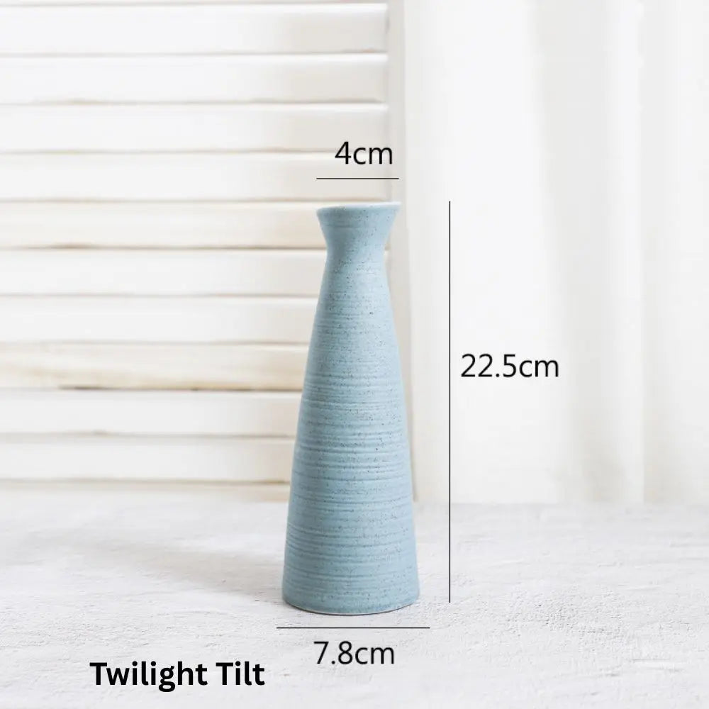 Sky blue ceramic vase, tall and slender with a 4cm opening, measuring 22.5cm high and 7.8cm wide, against a light background.