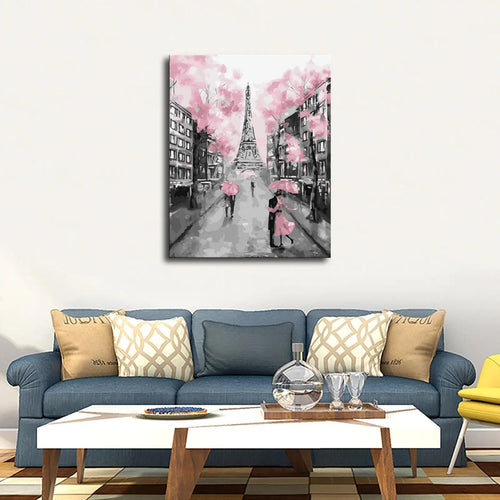 A romantic black-and-white painting of a couple under pink umbrellas in front of the Eiffel Tower, hanging above a stylish couch.