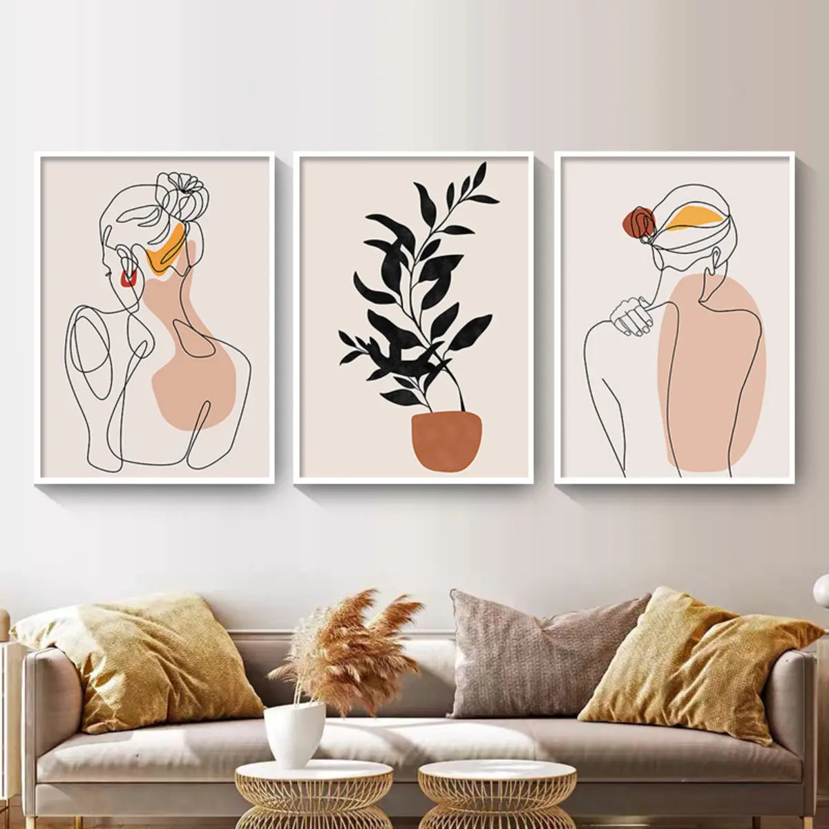 Three framed artworks depict minimalist line drawings of women and a leafy plant in a cozy living room setting with plush cushions.