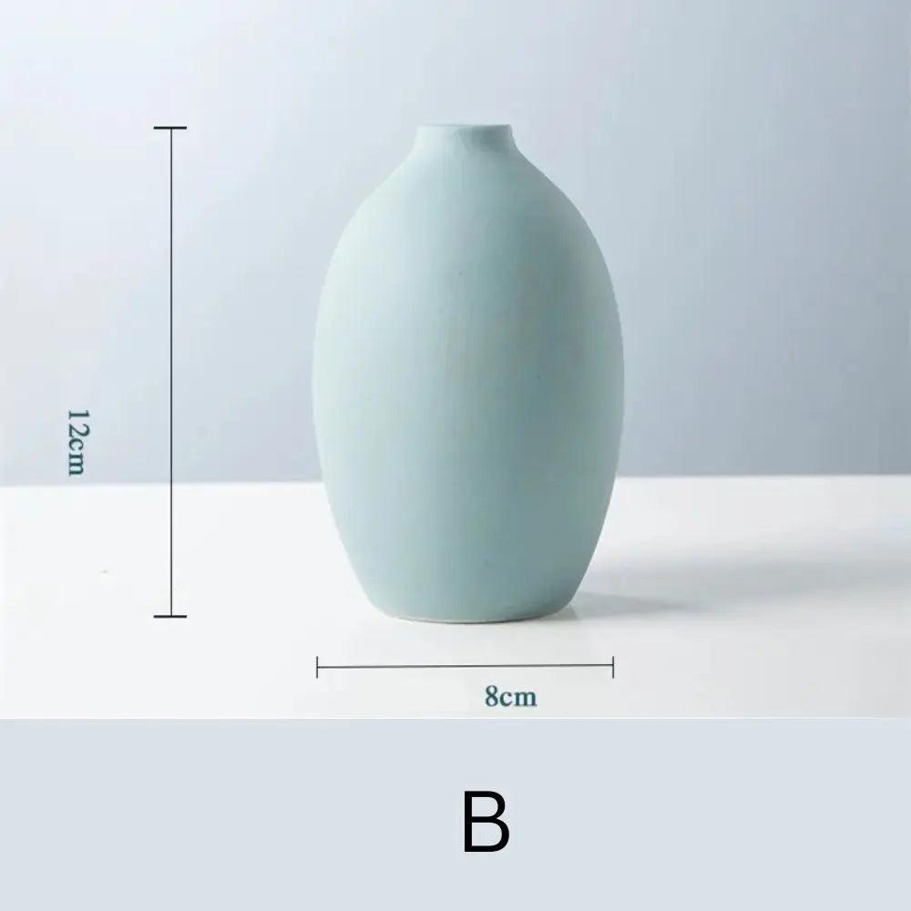 A simple, pastel blue ceramic vase with an oval shape, measuring 12cm tall and 8cm wide, displayed against a light background.
