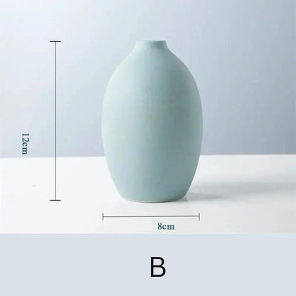 A simple, pastel blue ceramic vase with an oval shape, measuring 12cm tall and 8cm wide, displayed against a light background.