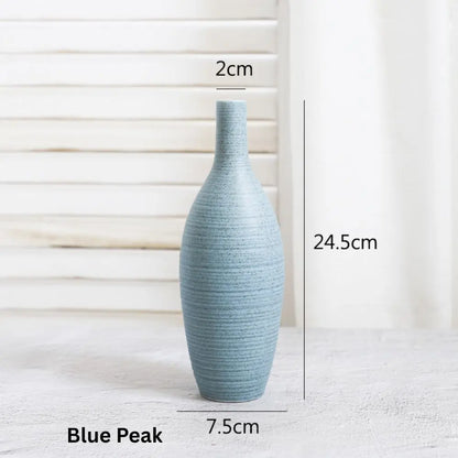 A light blue ceramic vase with a slender neck and textured surface, measuring 24.5cm tall and 7.5cm wide at the base.