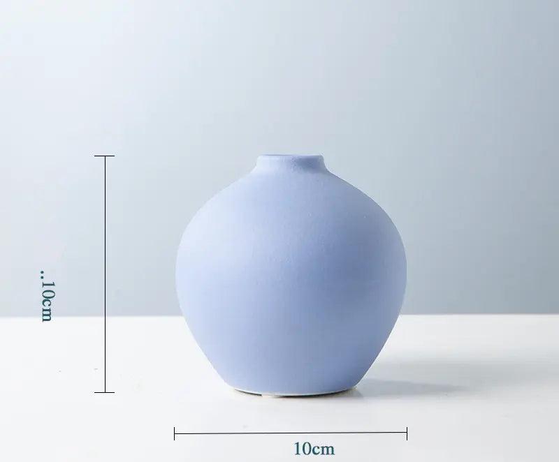 A round, matte blue vase measuring 10cm in height and diameter, displayed against a light background.